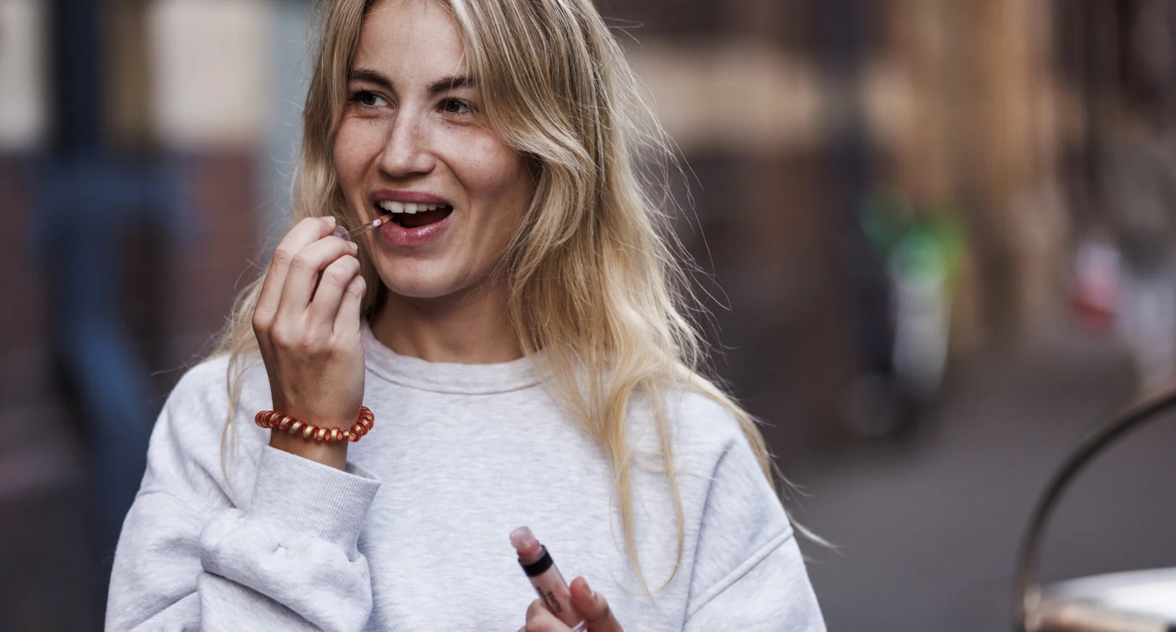 Vrouw smeer lipgloss op haar lippen