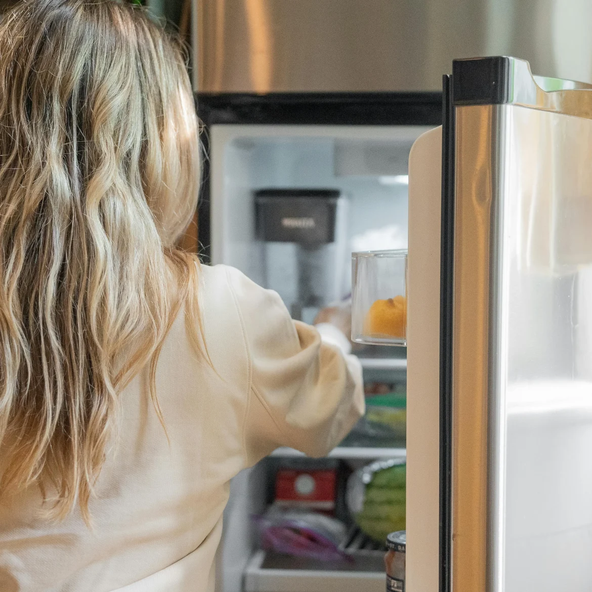 Vrouw bij koelkast, energie besparen
