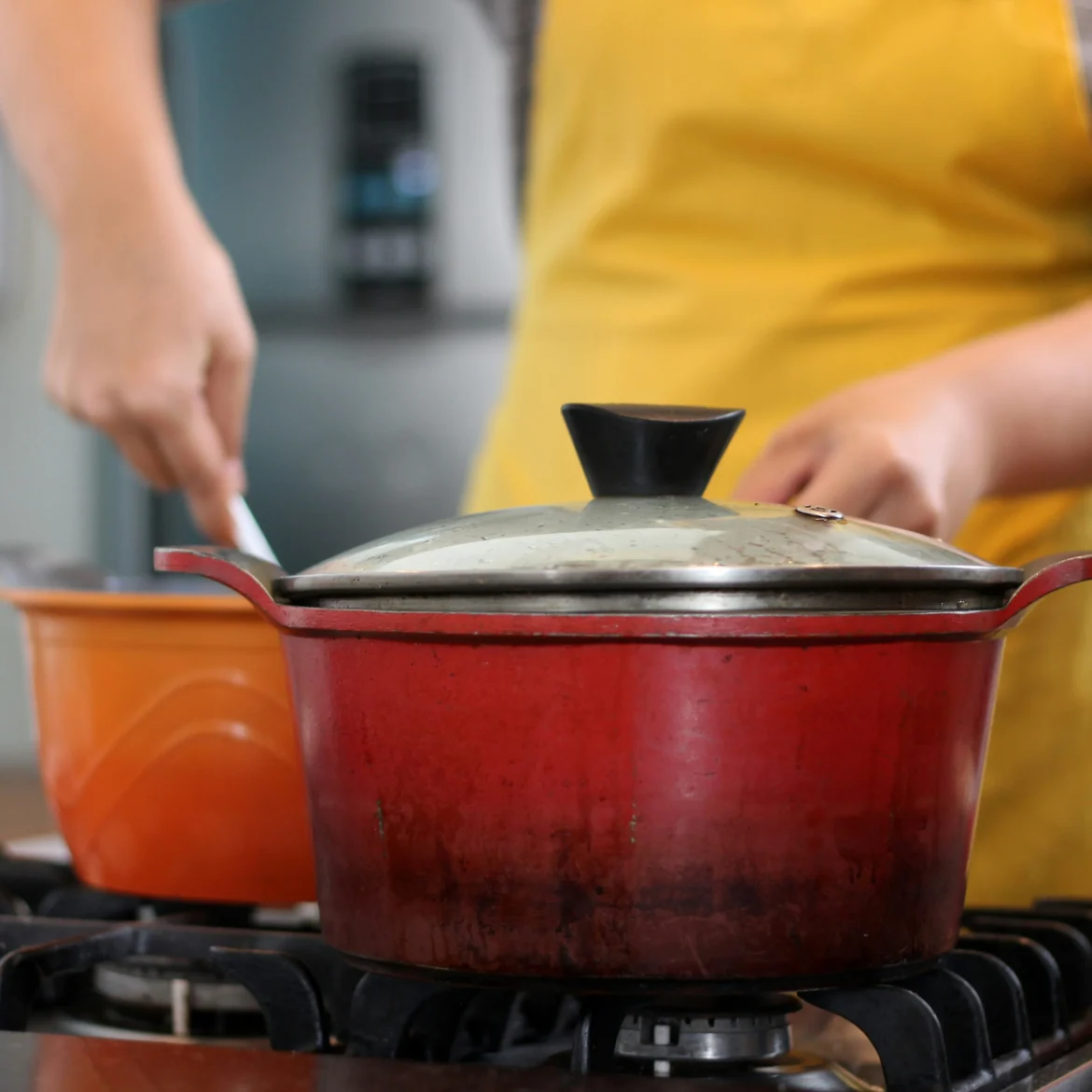 Vrouw kookt, de deksel zit op de pan zoals de bemoeiende buurman graag wil