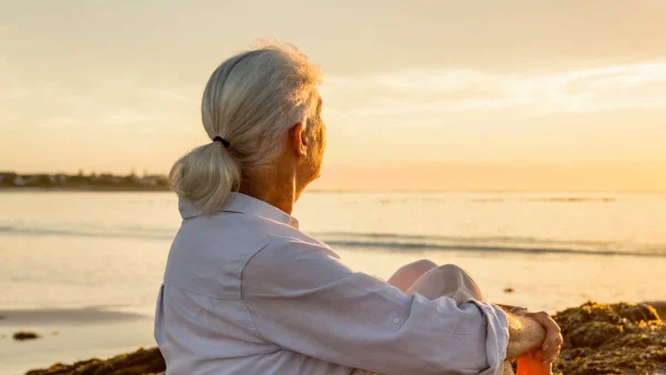 Vrouw kijkt naar zonsondergang