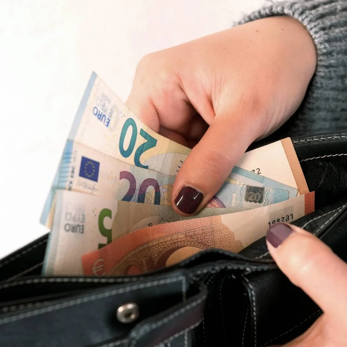 Vrouw haalt geld uit portemonnee