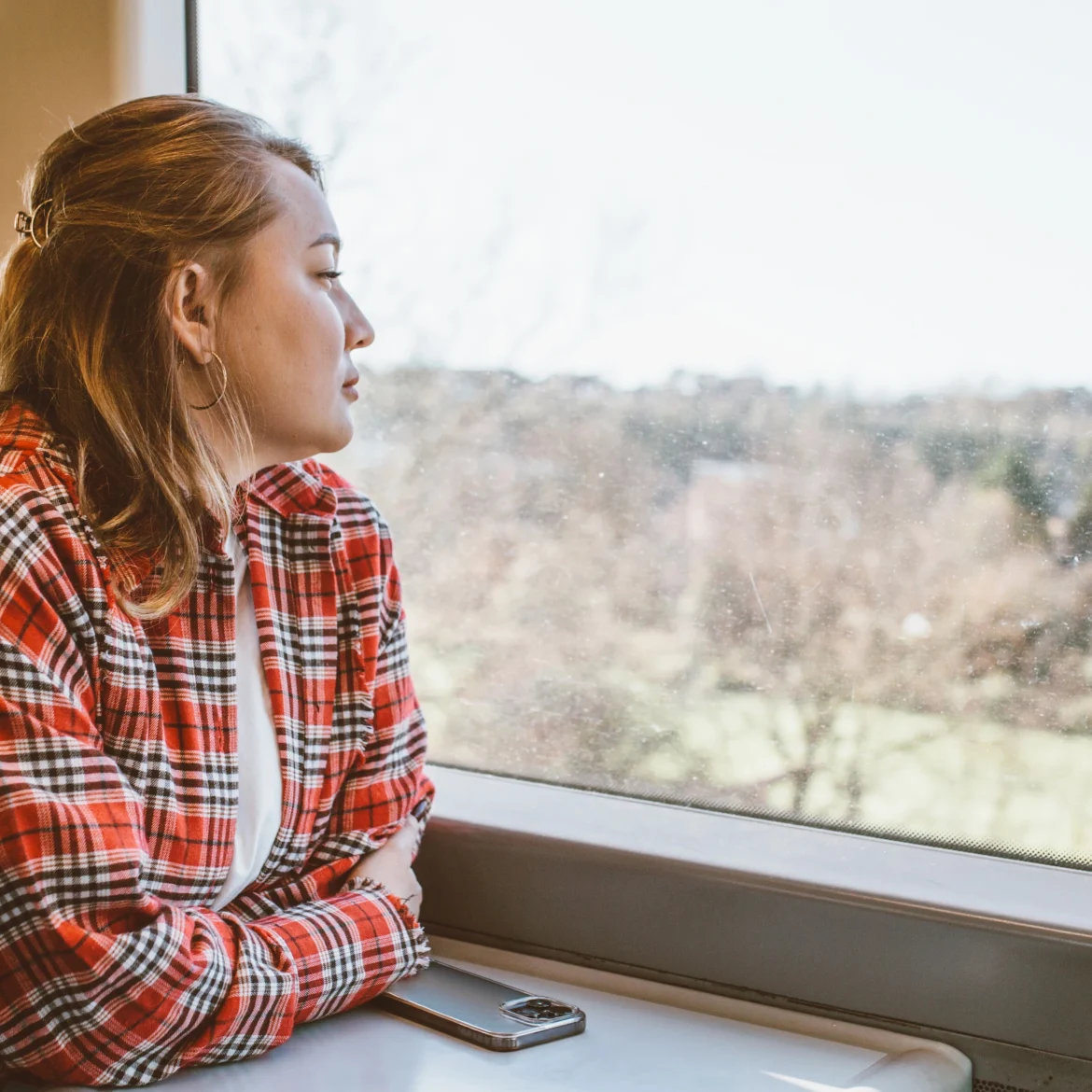 Britts vriendin verbraste al haar geld al op de tweede vakantiedag, illustratief beeld van een vrouw die uit het raam van een trein staart