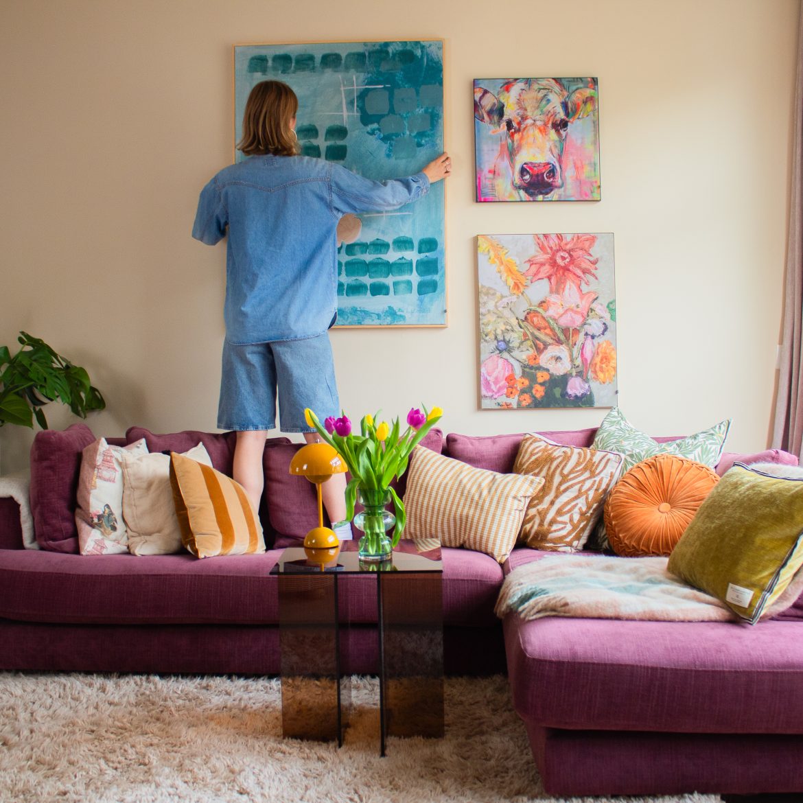 Vrouw hangt kunst aan muur