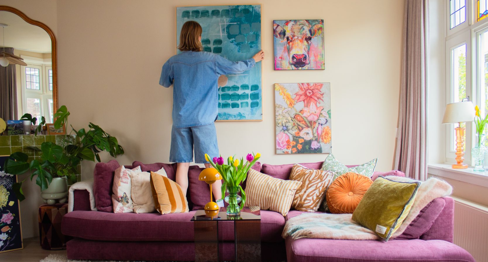 Vrouw hangt kunst aan muur
