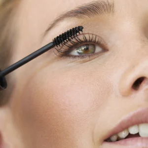 Vrouw met hooikoorts die make-up op doet