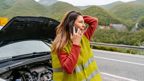Anne ging op vakantie naar Miami en alles ging mis. Illustratieve foto van een vrouw die met autopech langs de weg staat.