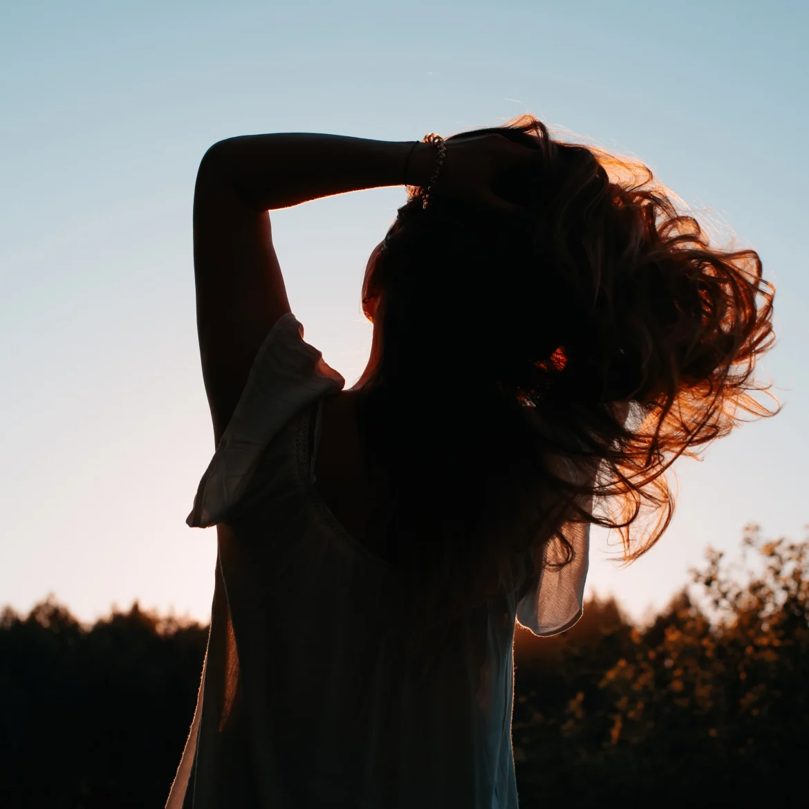 Illustratief beeld van een vrouw die in de zon kijkt bij een oproep voor mensen met een bijna-doodervaring