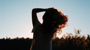 Illustratief beeld van een vrouw die in de zon kijkt bij een oproep voor mensen met een bijna-doodervaring