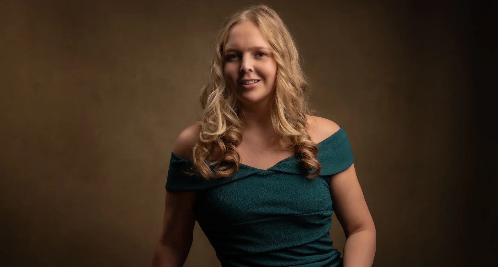 Esmee in een groene jurk. Ze wordt moeder en runt een high class escortbureau