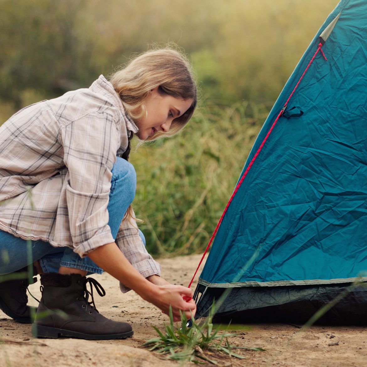Vakantieleed over vrouw die haar tentstokken war vergeten, beeld van vrouw die tent opzet