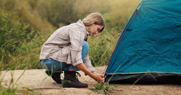 Vakantieleed over vrouw die haar tentstokken war vergeten, beeld van vrouw die tent opzet
