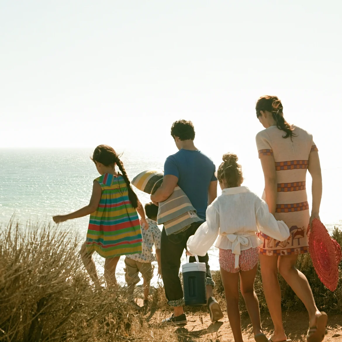 Een samengesteld gezin is op vakantie en loopt naar het strand