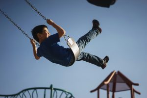 Oppaskind op schommel