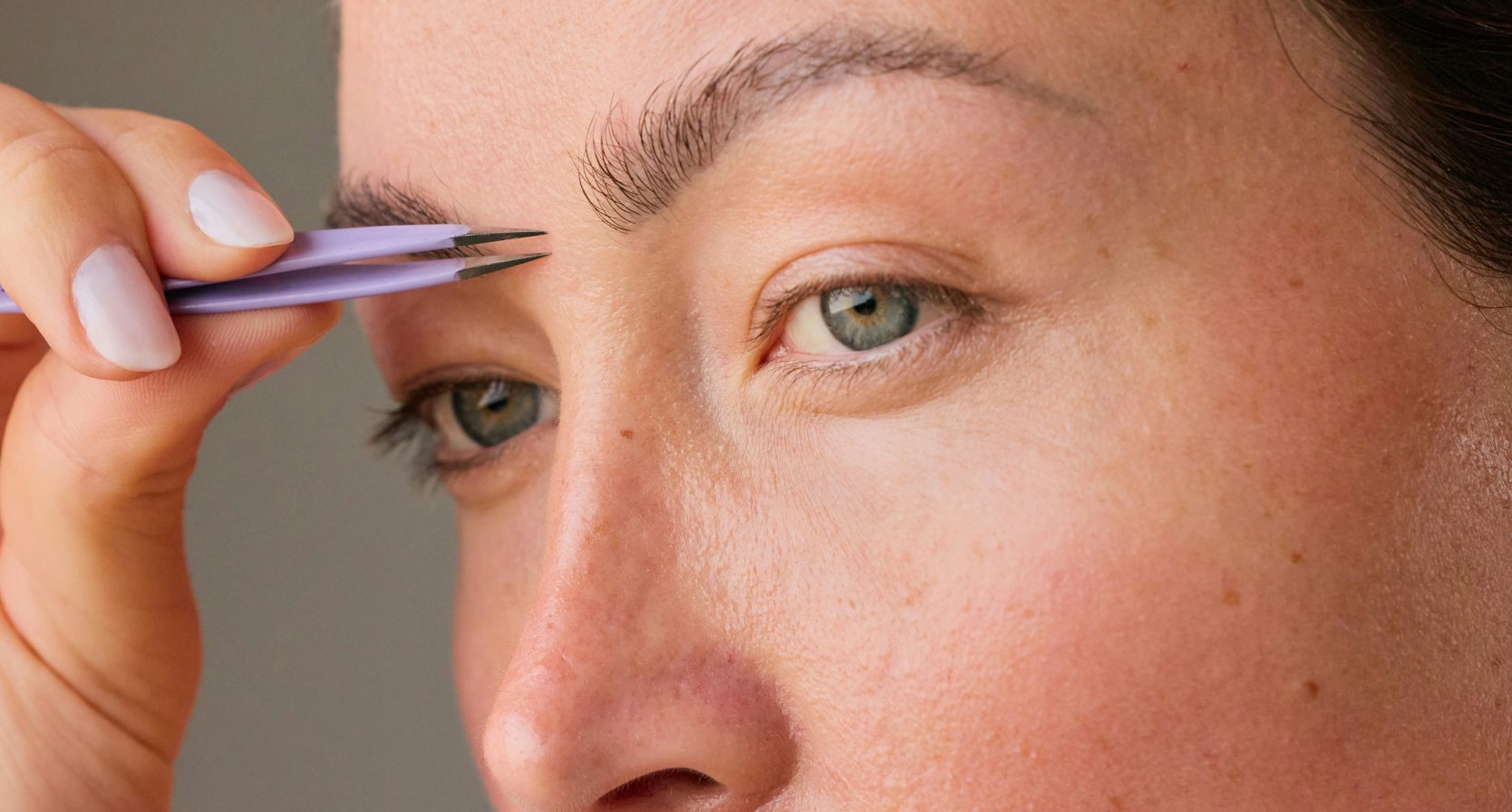 Vrouw is haar wenkbrauwen aan het epileren