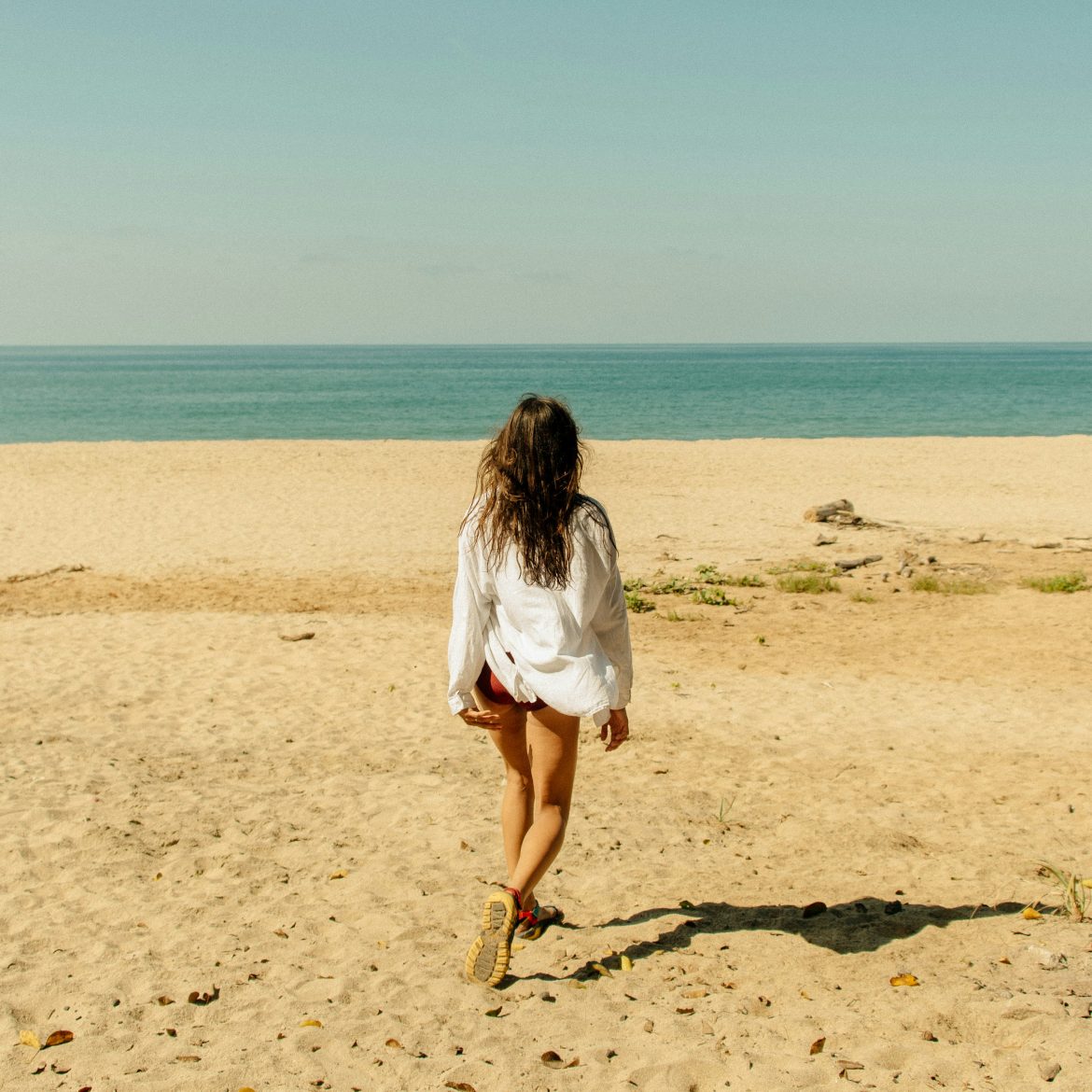 Vrouw op strand met blouse