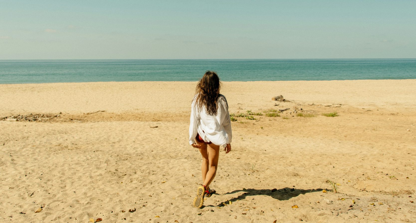 Vrouw op strand met blouse