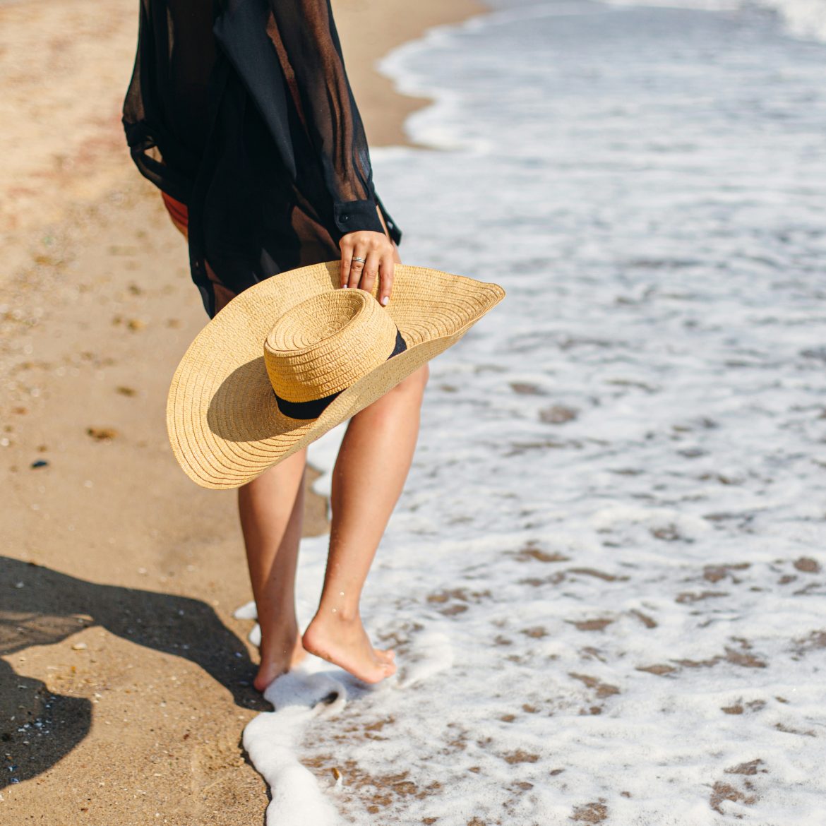 Vrouw met hoed op het strand