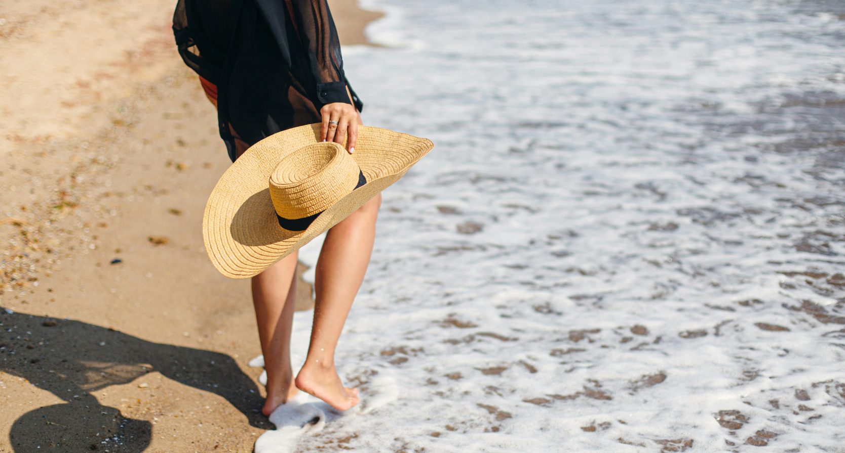 Vrouw met hoed op het strand