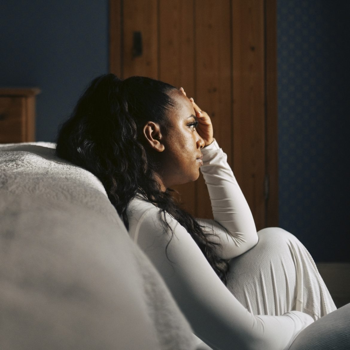 Vrouw leunt tegen haar bed en is laar met ongevraagd advies over haar samengestelde gezin