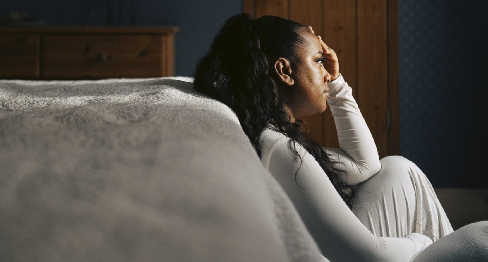 Vrouw leunt tegen haar bed en is laar met ongevraagd advies over haar samengestelde gezin
