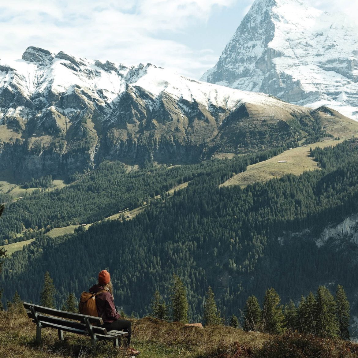 Vrouw geniet op een bankje van het uitzicht op een geweldig berglandschap in Zwitserland