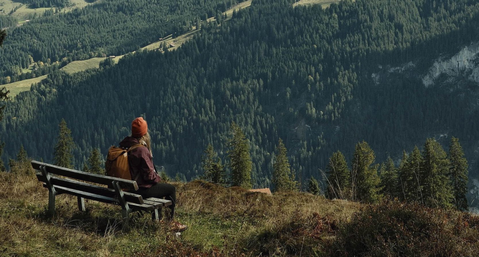 Vrouw geniet op een bankje van het uitzicht op een geweldig berglandschap in Zwitserland