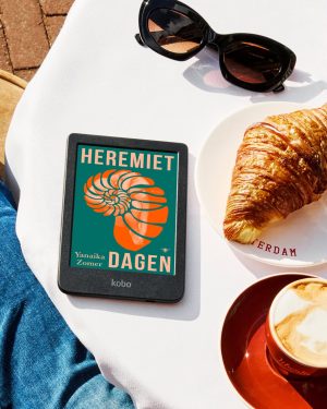 Heremietdagen in een kobo, met een croissant en zonnebril ernaast