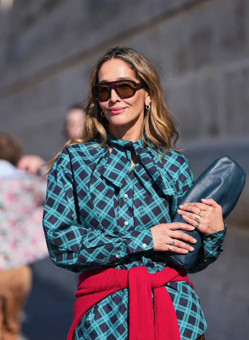 Vrouw met rode trui over blauwe blouse geknoopt