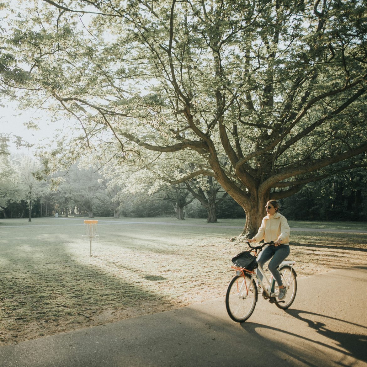 Vrouw fietsend door het zonnige park