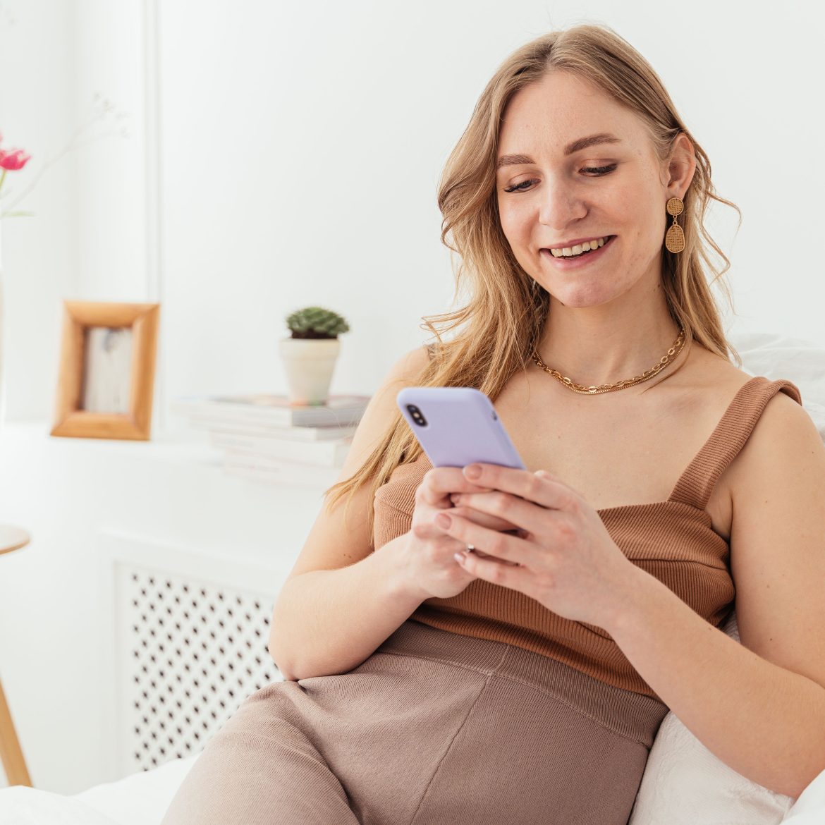 Een vrouw die lachend op haar telefoon zit