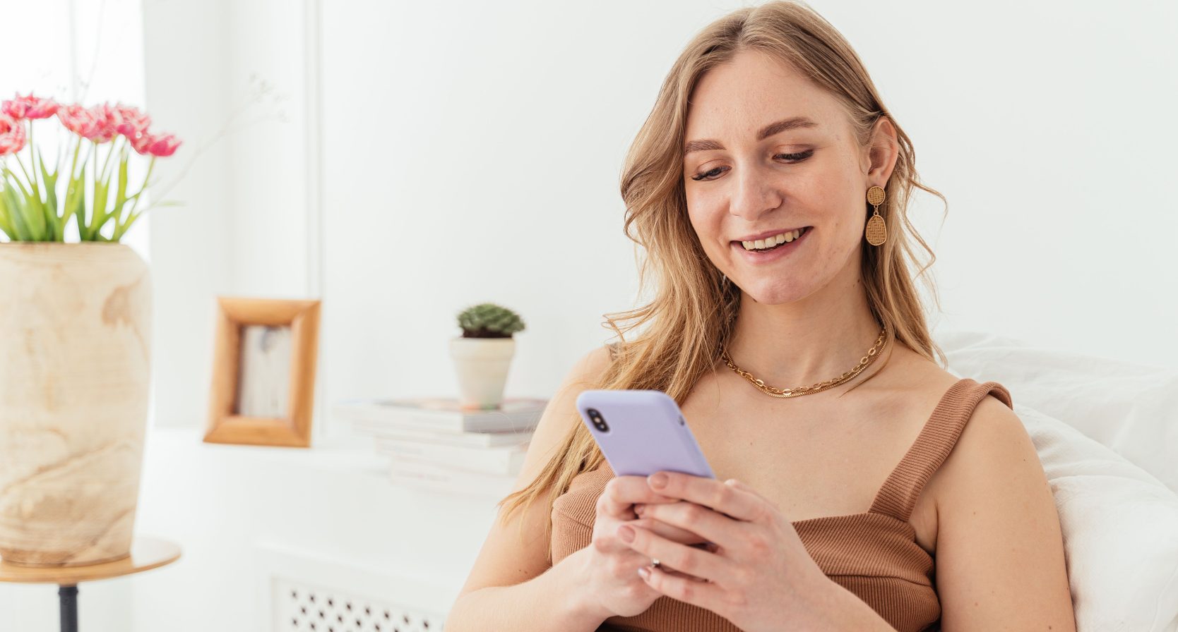 Een vrouw die lachend op haar telefoon zit