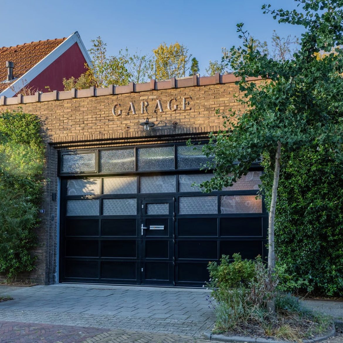 Foto buitenkant funda huis. Garagedeuren.