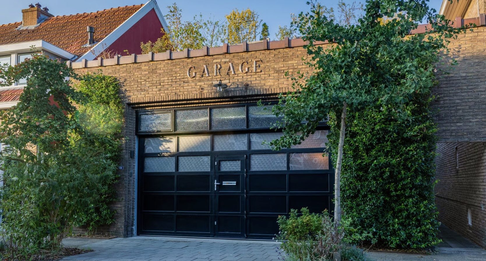 Foto buitenkant funda huis. Garagedeuren.