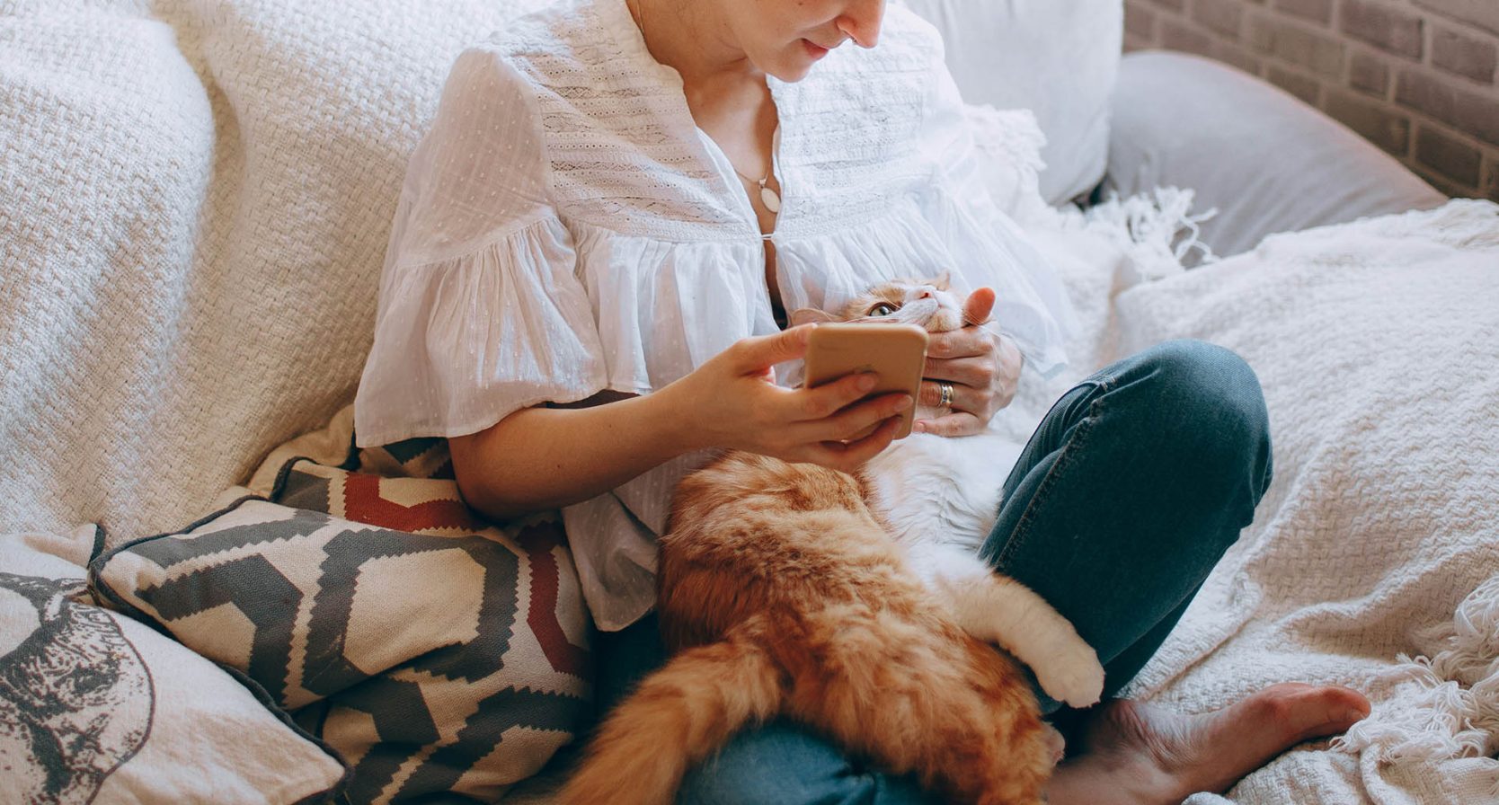 Vrouw op de bank met een rode kat op schoot