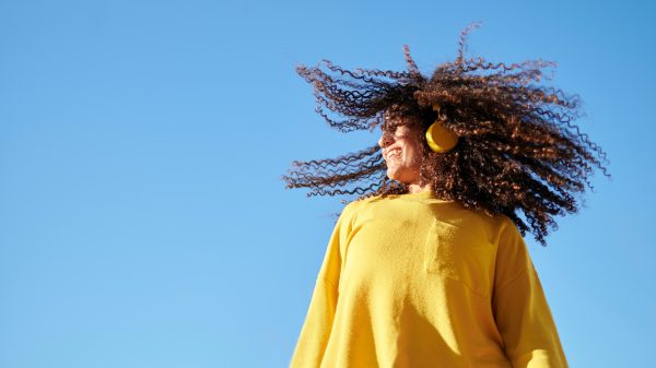 Illustratief beeld van een vrouw met een koptelefoon op bij luistertips van oktober