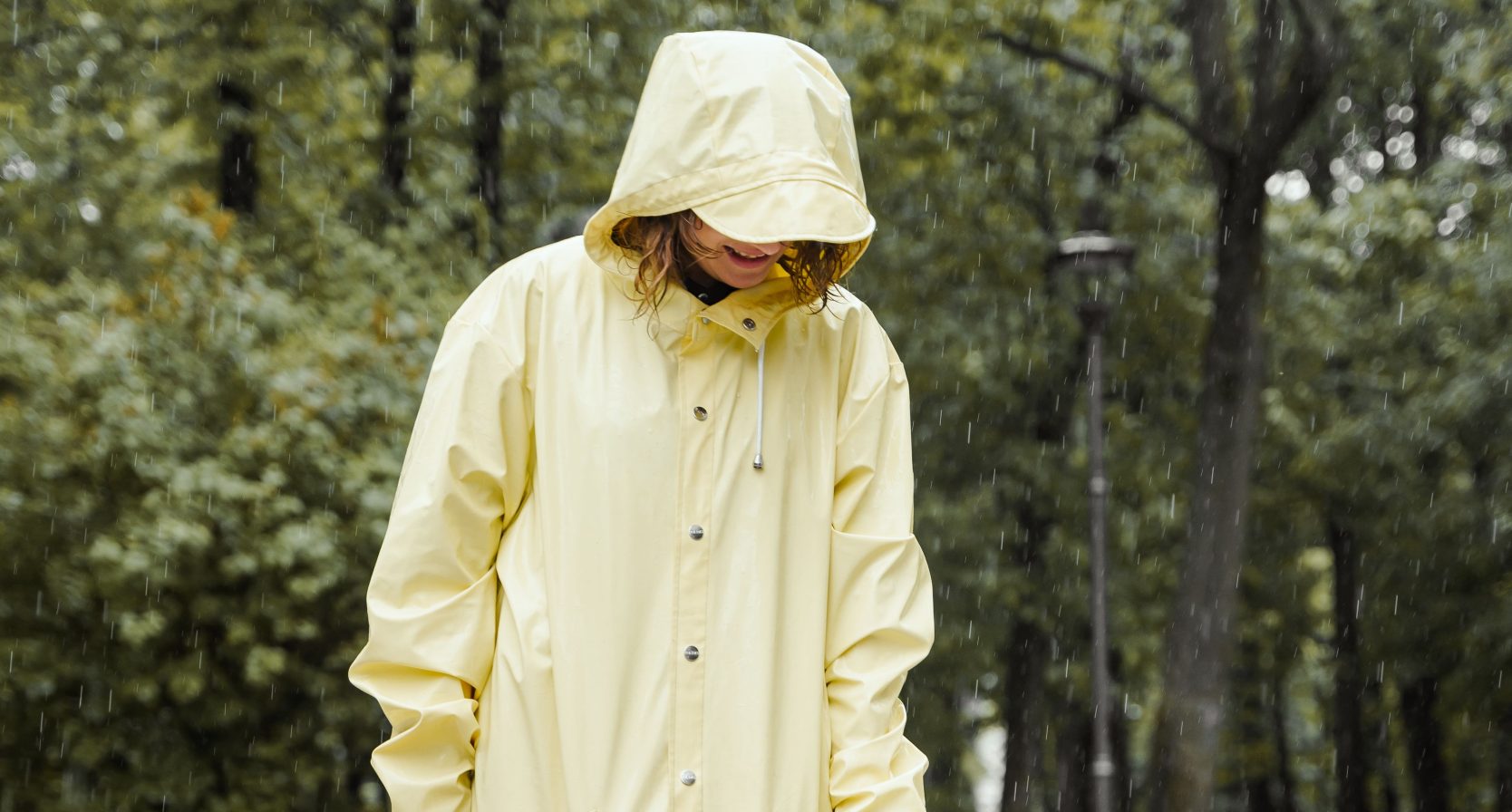 Vrouw in regenkleding, regenbuien op komst