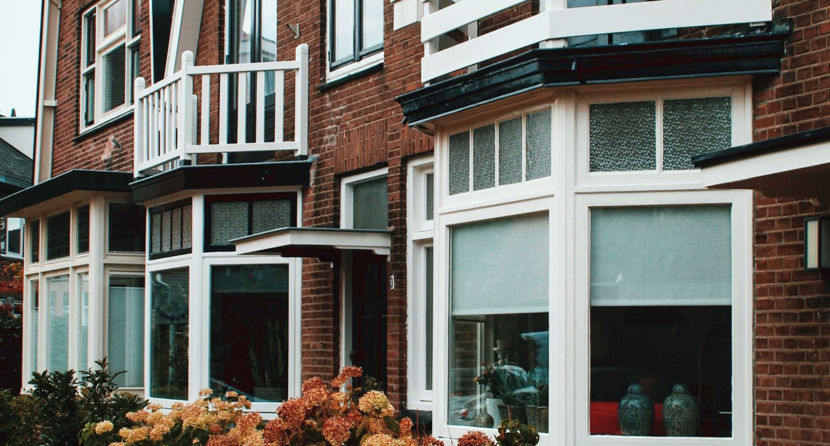 De gevels van een rijtje huizen met erkers