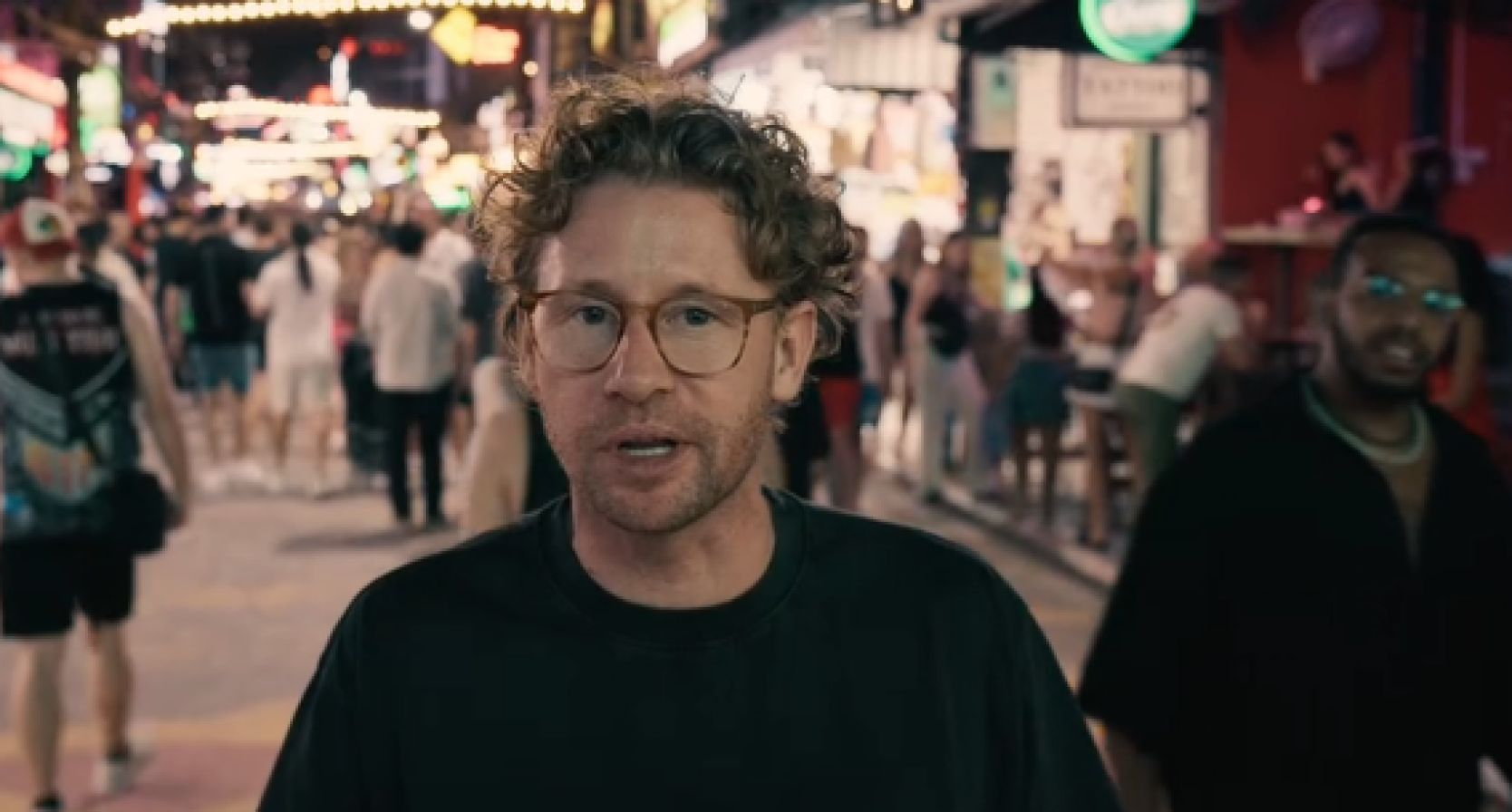Ewout Genemans vertelt voor de camera op een drukke straat in Thailand