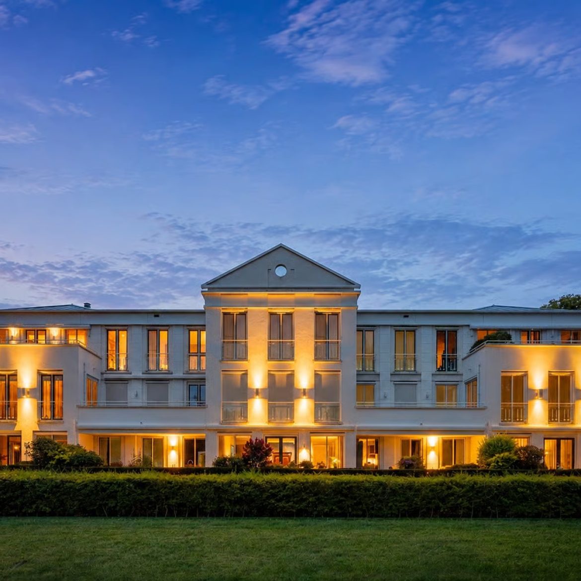 De gevel van een penthouse in Epe dat lijkt op het Witte Huis, bij schemering