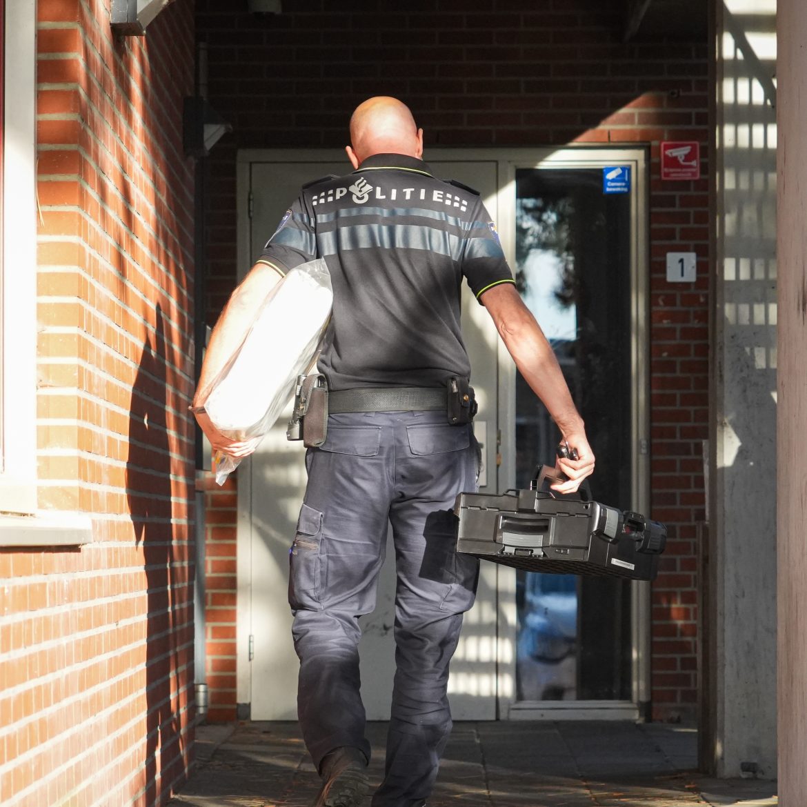 Een politieman komt aan bij een gebouw