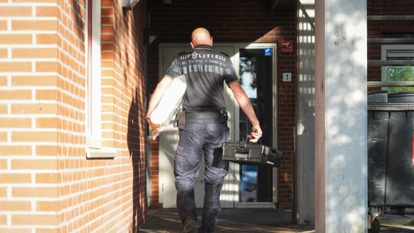 Een politieman komt aan bij een gebouw