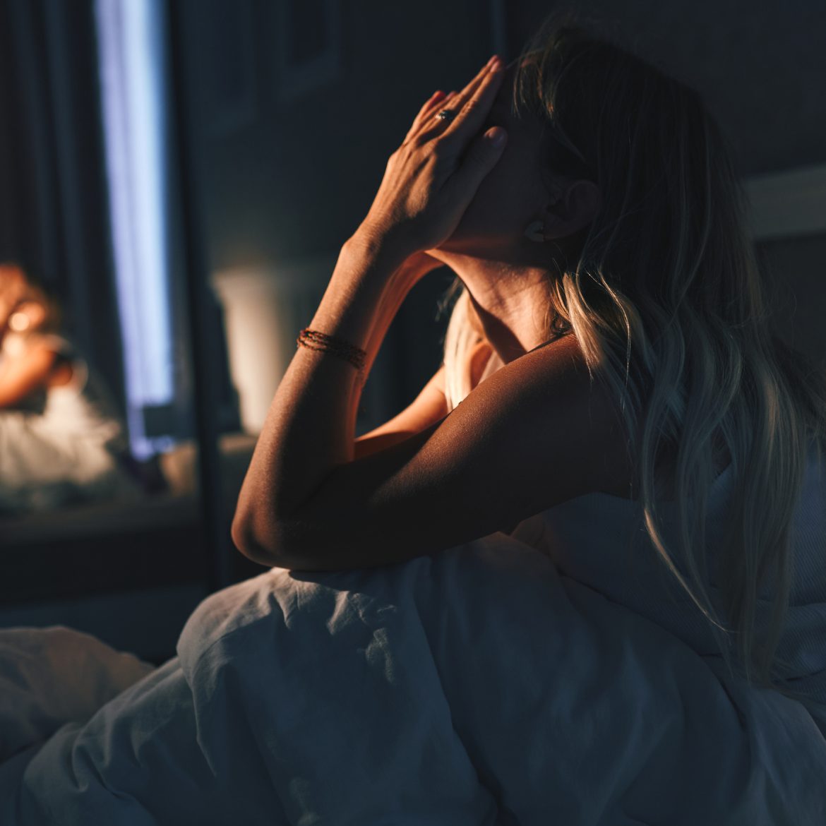 Vrouw zit rechtop in bed want haar buurman werkt 's nachts