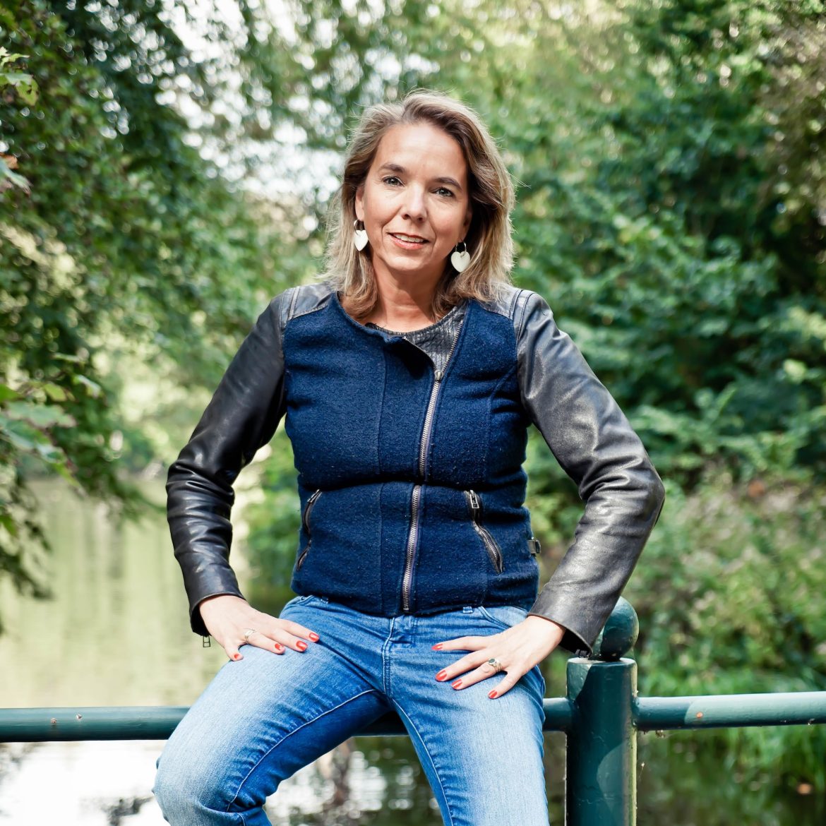 cornelie zittend op reling van brug